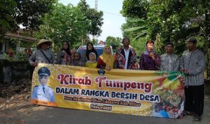 Kepala Desa Sumbersari, Hestiani (pakai jilbab kuning) menyapa setiap arak-arakan tumpeng yang melewati panggung kehormatan.