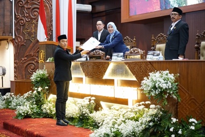 Anggota DPRD Jatim, Y. Ristu Nugroho memberikan PU Fraksi ke pimpinan DPRD Jatim yang disaksikan sekdaprov Jatim, Adhy Karyono. (Foto: DPRD Jatim)
