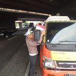 Anggota Dirlantas Polda Jatim membagikan bendera merah putih ke Sopir truk.